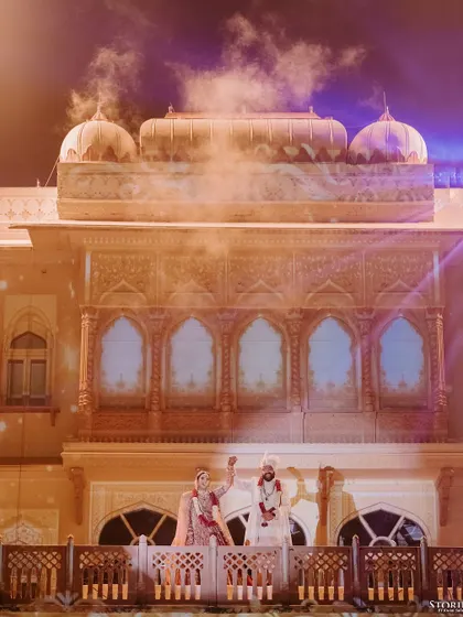 The couple waving to their guests from the palace balcony, a moment of shared joy and celebration.