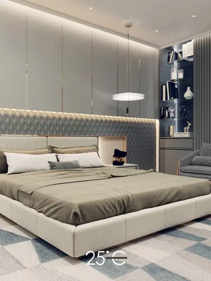 A serene and sophisticated bedroom design featuring a cool grey color palette. The custom headboard incorporates a quilted texture and integrated backlighting, while a built-in shelf and reading nook add functionality.