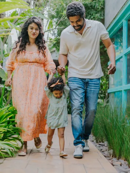 A family takes a walk together through a beautiful garden path. This action shot captures their connection and the feeling of moving forward together as a family.
