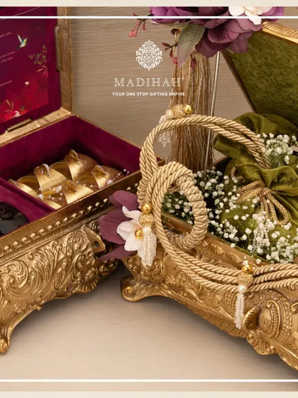 Two distinct Rajwada chests side-by-side, one with a deep red velvet interior for a wedding invite and another with an olive green lining for gourmet gifts, showcasing the versatility of the design.