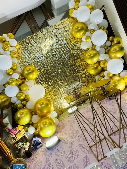 A high-angle view showcasing the layout of the gold sequin backdrop, balloon arrangement, and floor decor. This perspective shows how all the elements work together to create a complete decorative package.