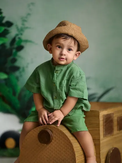 A sweet and classic portrait from an indoor session. The combination of a simple outfit, a cute hat, and a themed backdrop creates a timeless look.