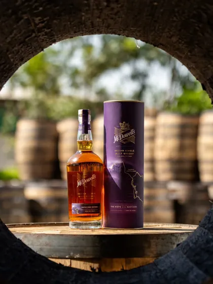 A product shot of the McDowell's bottle and its packaging, framed through a barrel. This creative composition reinforces the theme of cask maturation.