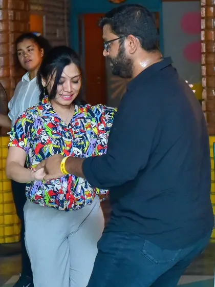 A stylish couple enjoying a dance. The comic book shirt is a fun touch.