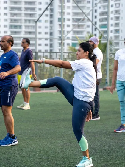 A member performs a dynamic leg kick during the warm-up phase of our rooftop bootcamp.