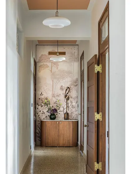 A full view of the hallway in Apartment 5026, with its beautiful wallpaper, Art Deco-inspired lighting, and original terrazzo floor.