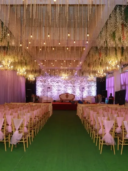 Synergy Banquet in Vashi, available for just 60k with decor. The ceiling is adorned with hanging flowers and lights, creating an enchanting atmosphere.