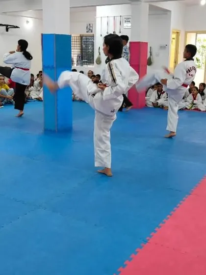 A class of students practicing their kicks in unison.