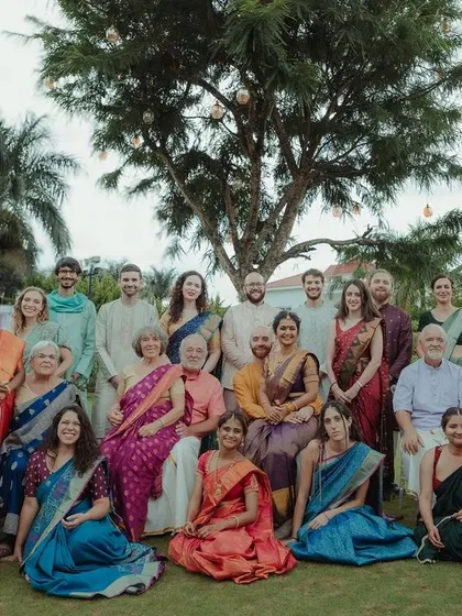 A family portrait from a two-country wedding, filled with smiles and traditional attire. Capturing the collective joy of the families is a key part of our storytelling.