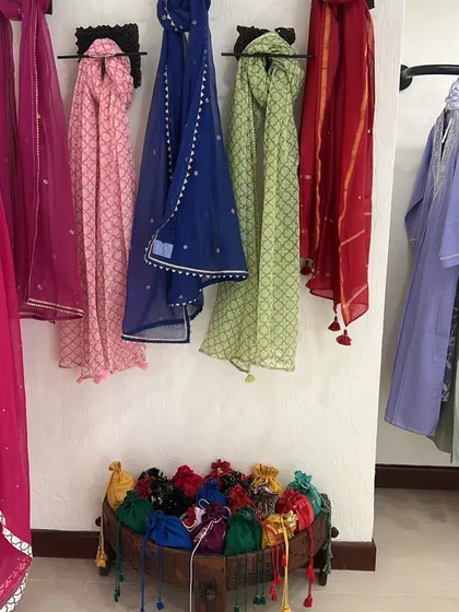 A colorful display of dupattas and potli bags in a Jaipur shop. These small accessories are perfect for adding a pop of color and a traditional touch to any outfit.