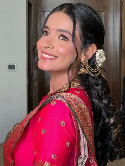 A side profile showcasing the elegant hairstyle with fresh flowers and the beautiful glow on her skin.