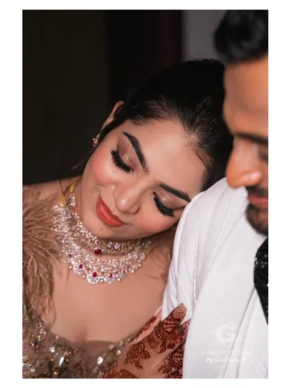 A romantic close up of Reshma. The makeup features shimmering eyeshadow and a glossy lip, creating a look that is both glamorous and tender.