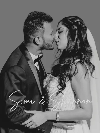 A timeless black and white kiss. This studio-style portrait is perfect for capturing the classic romance of a wedding day, focusing on the couple's intimacy.