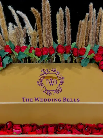 A closer look at our exquisite floral gift box. The arrangement of red roses and pampas grass around a golden gift box is pure luxury.
