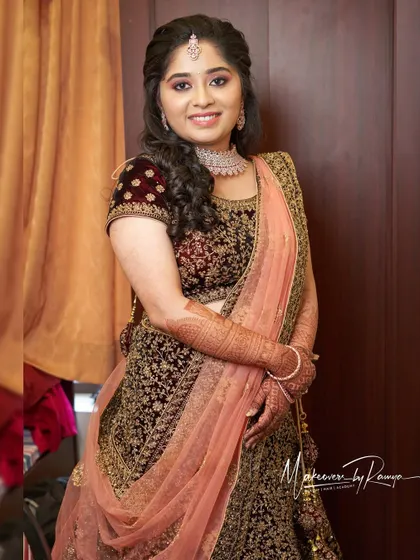 Vidhatri's reception look in a deep velvet lehenga. The soft curls and diamond jewelry create an elegant and sophisticated style.