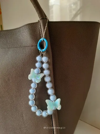 A beautiful blue-on-blue combination. This beaded charm with two-tone blue butterflies and a matching clasp is perfect for adding a cool, serene vibe to your bag.