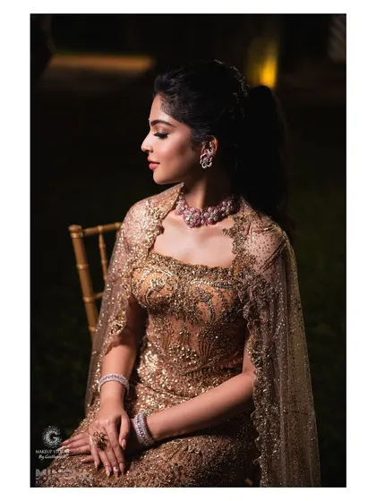 Sindhu looking serene and elegant for her engagement party. The makeup features a soft, smokey eye and a neutral lip, allowing her sparkling gold gown and diamond jewelry to take center stage.