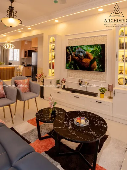 A bright and airy living room with a white TV unit flanked by glass display cabinets, creating a balanced and elegant look.