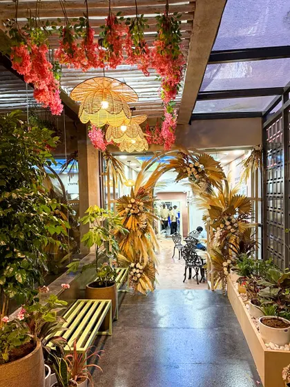 Another view of the enchanting entrance at Organic Creamery. The combination of living plants, dried florals, and warm lighting creates a multi-sensory experience that is both beautiful and memorable.