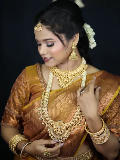 A classic South Indian bridal look. The makeup is kept warm and golden to match the traditional gold jewelry and the rich texture of the silk saree.