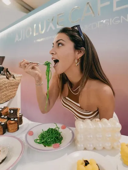A guest enjoying our signature green spaghetti at the Ajio Luxe Café. Seeing people delight in our creative dishes is the best part of any event.
