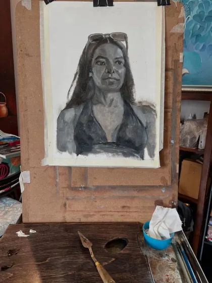 Another view of the monochrome portrait on my easel, with my palette knife and paints nearby. This setup is typical for my studio practice.