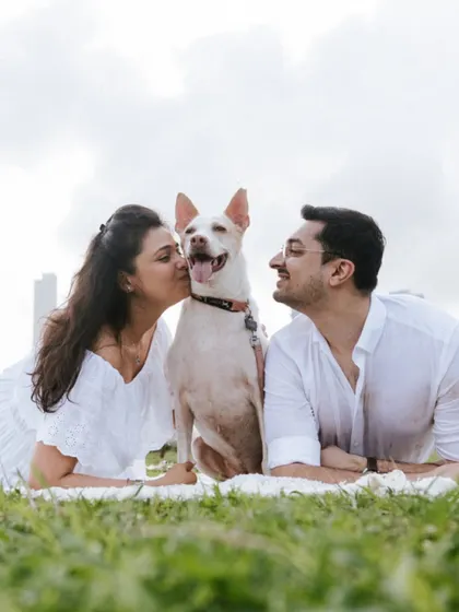 The perfect family portrait. This photo captures the couple and their adorable dog enjoying a moment together in the park. Including pets makes the session so much more personal.
