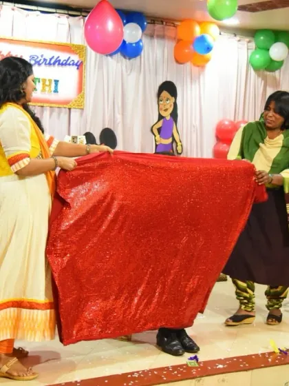 What's under the shiny red cloth? Two audience members help me create a moment of suspense before the big reveal during a levitation illusion.