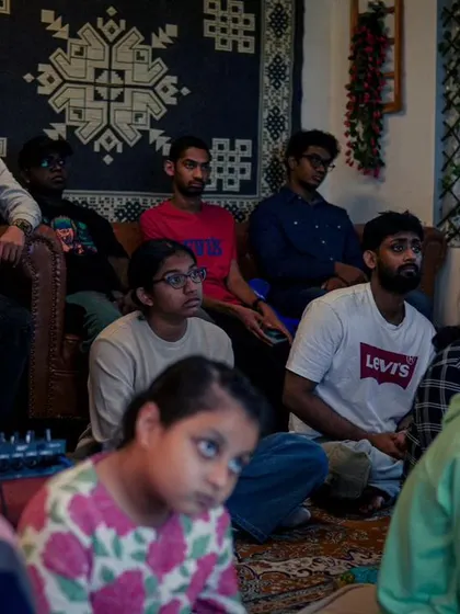 A group of students listening intently during a vocal workshop.