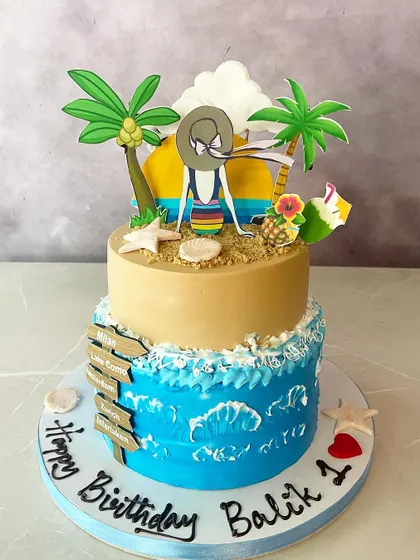 For the friend who is always dreaming of the beach! This two-tier cake brings the vitamin sea to the party, with edible sand, waves, palm trees, and a relaxing beachgoer.