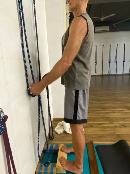 A senior student using wall ropes and a block to work on balance and foot strength. The practice can be adapted to any age and ability.