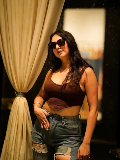 A confident pose in front of a curtain, with the light creating a beautiful silhouette.