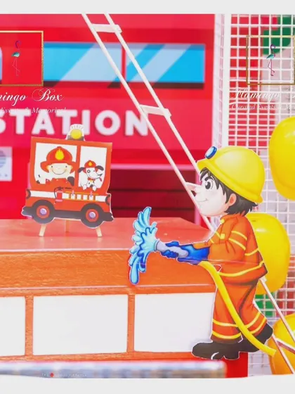 A detail shot of the fire station backdrop, with a firefighter cutout and themed props.