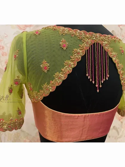 A stunning blouse with a sheer green net back and sleeves, adorned with pink and gold floral embroidery and hanging bead tassels.