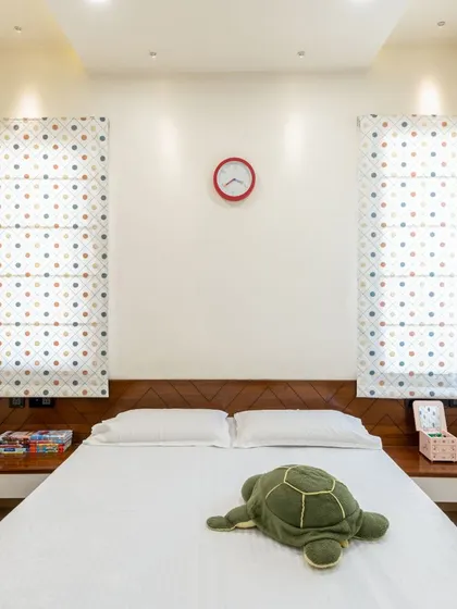 The symmetrical design of this bedroom, with its matching bedside tables and polka-dot blinds, creates a sense of calm and order.
