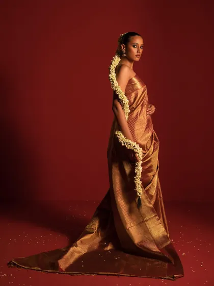 A stunning Kanjivaram-style saree in gold, styled with a long jasmine gajra. This look is a tribute to South Indian bridal traditions, showcasing timeless elegance.
