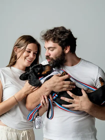 A beautiful studio portrait of a couple and their dachshund. This image is a reminder to get those professional photos taken with your pets, not just blurry selfies!