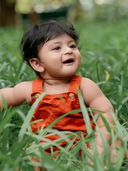 Exploring the tall grass with a big smile. We love capturing these moments of pure, unscripted joy.