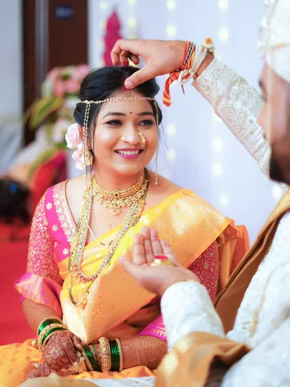 A beautiful moment during the wedding ceremony as the groom applies the bindi to his bride's forehead, a symbol of their union.