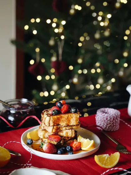 A festive breakfast scene with French toast in front of a Christmas tree. This shot combines a delicious meal with a classic holiday backdrop, creating a perfect seasonal image.