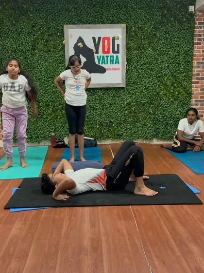 A student practices core-strengthening exercises, a key component for building the stability needed for more advanced yoga poses.