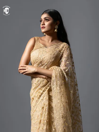 This elegant gold net saree is perfect for creating a classic and sophisticated look. The sheer fabric with gold embroidery photographs beautifully.