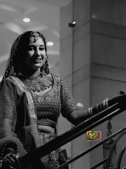 A candid black and white shot of the bride on the stairs. Her natural smile and the simple composition create a beautiful, unposed moment.