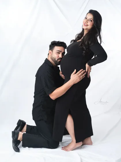 A playful and loving embrace. The dad-to-be hugs his wife from behind, a pose that is both fun and full of love.