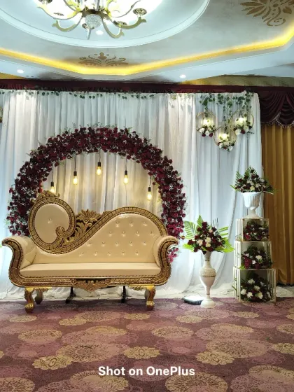 This is a full view of a baby shower stage I designed and photographed in Chandapura. The setup features a rich maroon floral arch, elegant vintage-style seating, and soft lighting to create a warm, celebratory atmosphere perfect for capturing beautiful portraits.