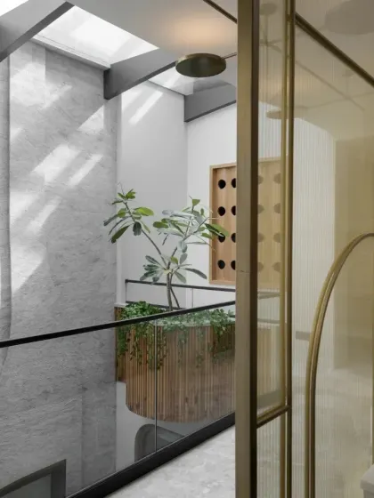 With no side windows, bringing light into the Slender House was a challenge. I designed a central skylight over the void to illuminate the internal courtyards, reducing the need for artificial light and creating this dramatic, airy stairwell.