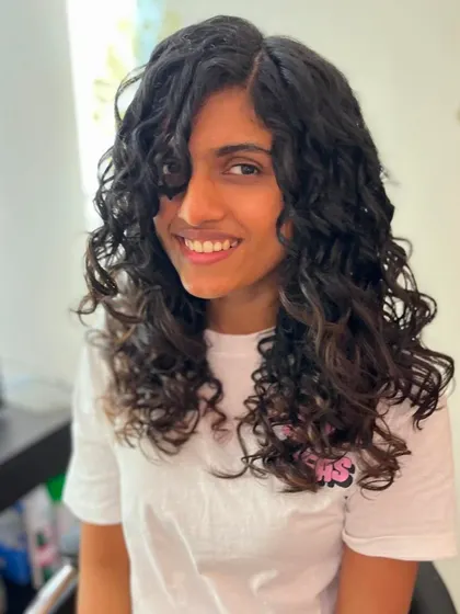 The client enjoying her new voluminous curly hairstyle.
