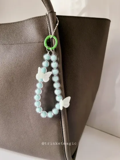 This version of my butterfly charm features light blue beads and a bright green clasp, offering a fresh and vibrant color combination.