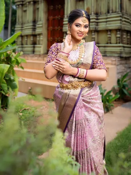 A beautiful bride in a lavender and pink silk saree, perfect for a reception or engagement. The intricate embroidery on the blouse adds a touch of luxury.