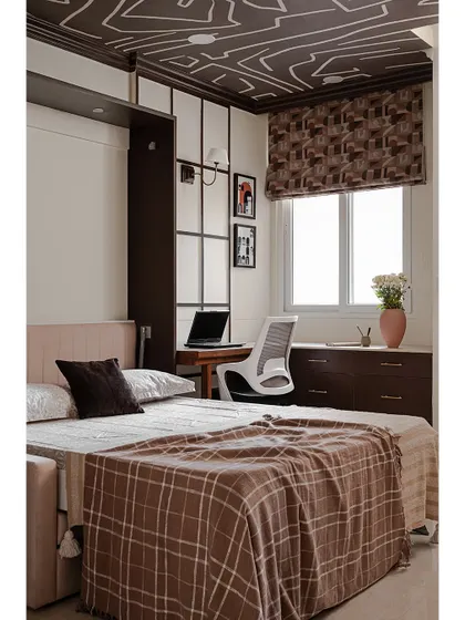 The same studio room with the Murphy bed pulled down. This space-saving solution allows the room to function as both a comfortable bedroom and a practical home office without feeling cluttered.